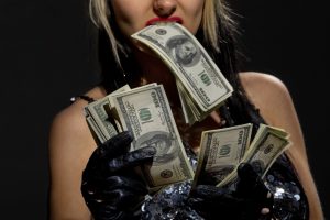 photo of woman holding money in teeth