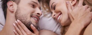 Man and woman in bed laughing together